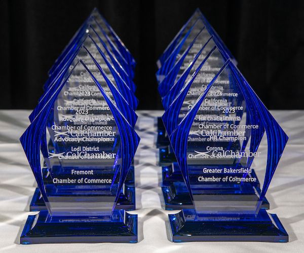 Rows of blue acrylic CalChamber awards, inscribed with names of California cities.