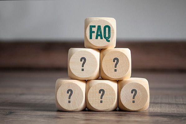 Wooden blocks form a pyramid of question marks topped by a block labeled FAQ.