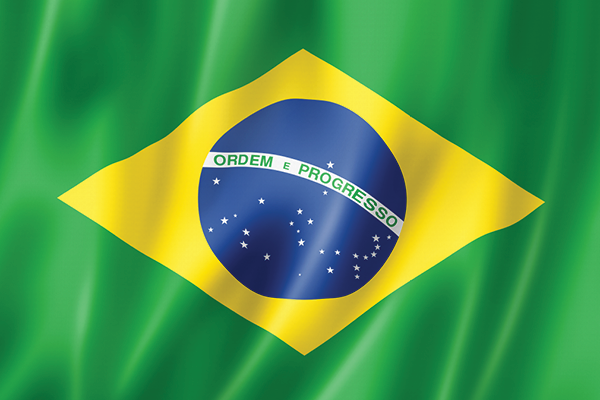 Brazilian flag with its blue globe and yellow diamond on rippling green fabric.