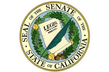 California State Senate seal with a quill, scroll, wreath and gold border.