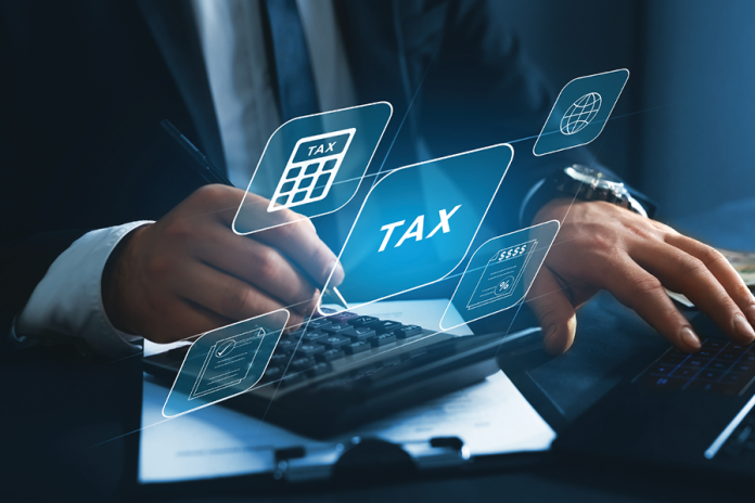 A person uses a calculator and laptop beneath floating tax-related interface icons.