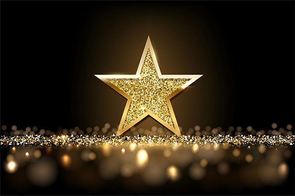 A glittering gold star stands amid sparkling golden lights against black.