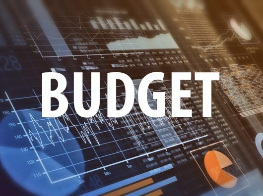 BUDGET in large white letters over financial graphs and charts.