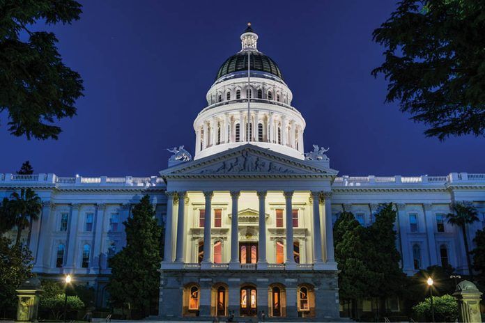 The illuminated California State Capitol beneath a deep blue evening sky.