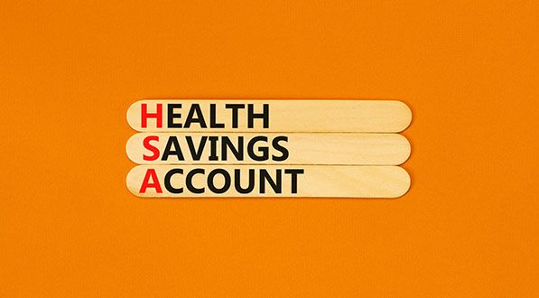 Wooden sticks spell Health Savings Account, with HSA highlighted in red on an orange background.
