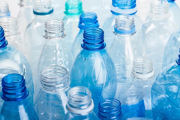 A tightly grouped collection of empty clear and blue plastic bottles.