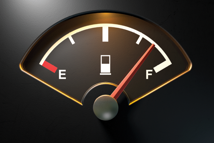 An illuminated fuel gauge with its needle pointing toward full.
