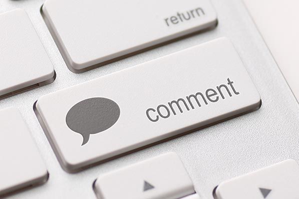Close-up of a keyboard key labeled comment with a speech bubble icon.