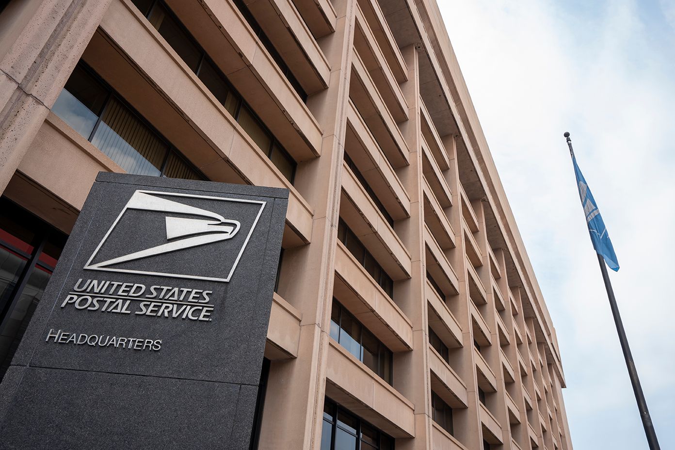 United States Postal Service headquarters sign outside a large office building.