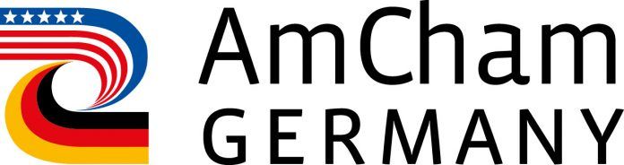 AmCham Germany logo with a ribbon combining U.S. and German flag colors.