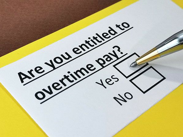 A form asks 'Are you entitled to overtime pay?' with Yes and No checkboxes beside a pen.