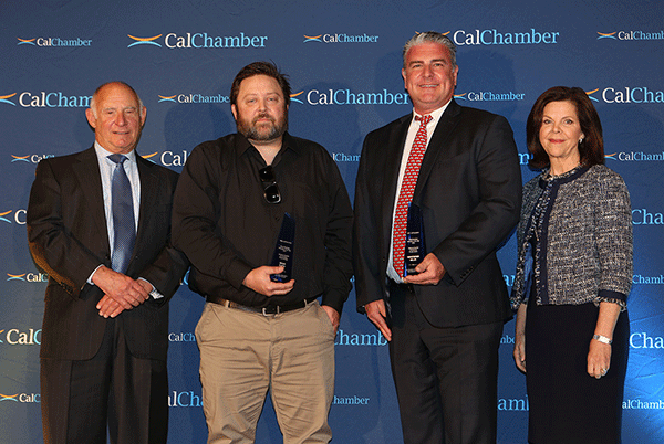 Four people pose against a CalChamber backdrop, with the two center men holding awards.