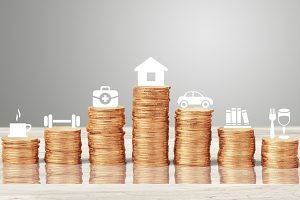 Stacks of coins topped with icons for housing, healthcare, transportation, food and other expenses.