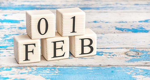 Wooden date blocks display 01 FEB on a weathered blue and white surface.