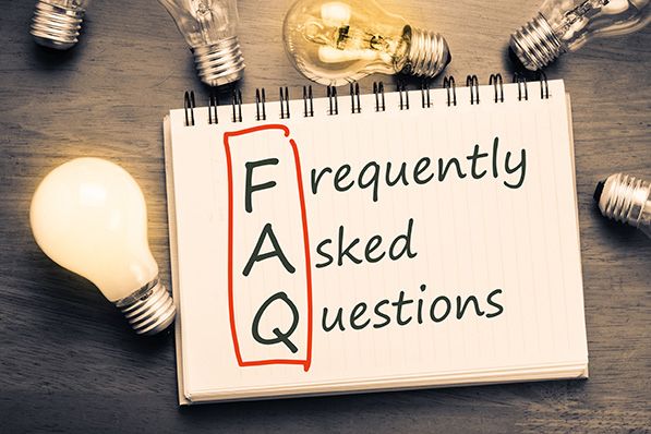 A notebook reads Frequently Asked Questions, with FAQ boxed in red and lightbulbs arranged around it.