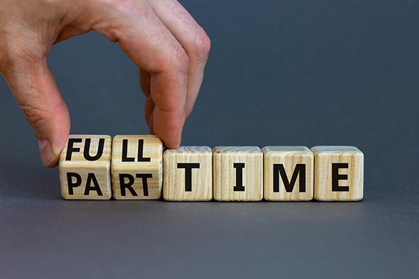 A hand changes wooden blocks between FULL TIME and PART TIME.