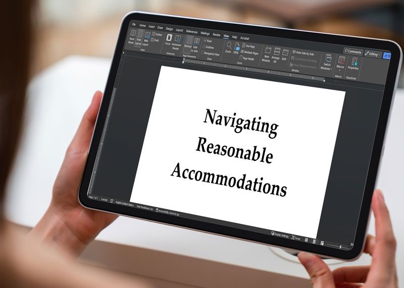 Hands hold a tablet displaying a document titled Navigating Reasonable Accommodations.