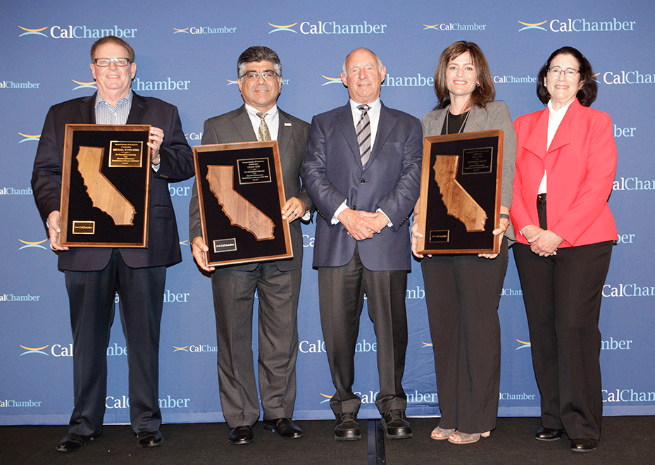 Five people stand before a CalChamber backdrop, three holding framed California awards.