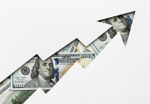 An upward zigzag arrow filled with U.S. dollar bills on a white background.