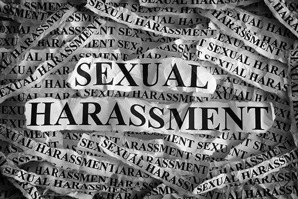 The words Sexual Harassment repeated in black lettering across a wrinkled newspaper-like surface.