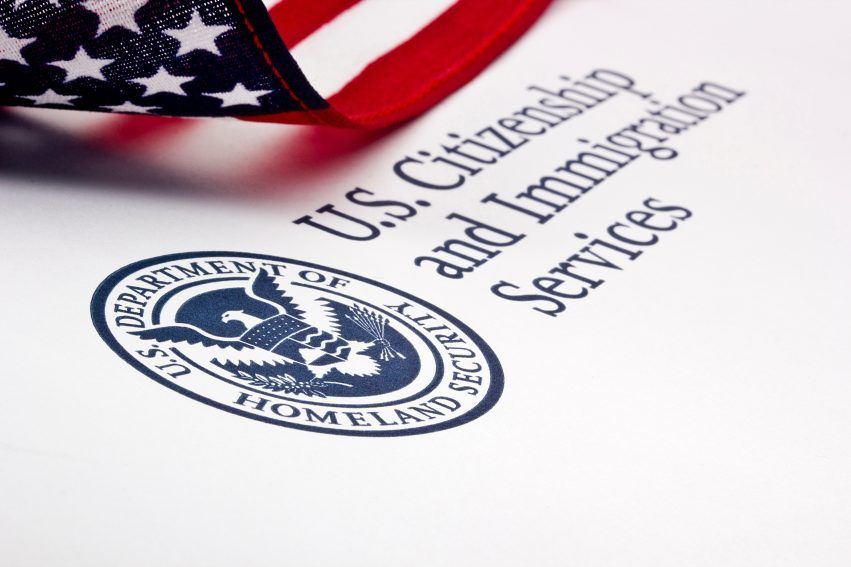 U.S. Citizenship and Immigration Services document with a Department of Homeland Security seal beside an American flag.