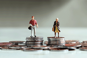 Miniature figures of two people stand on separate stacks of coins.