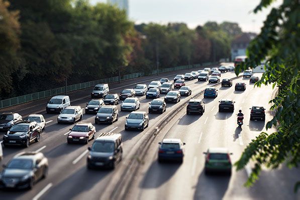 A tilt-shift photo shows heavy traffic on a multi-lane road.