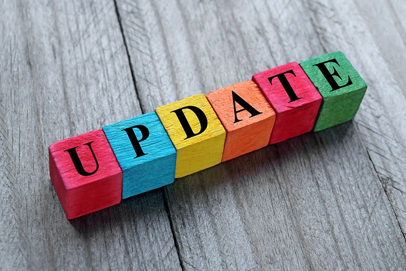 Colorful wooden blocks spell UPDATE on a gray wooden surface.