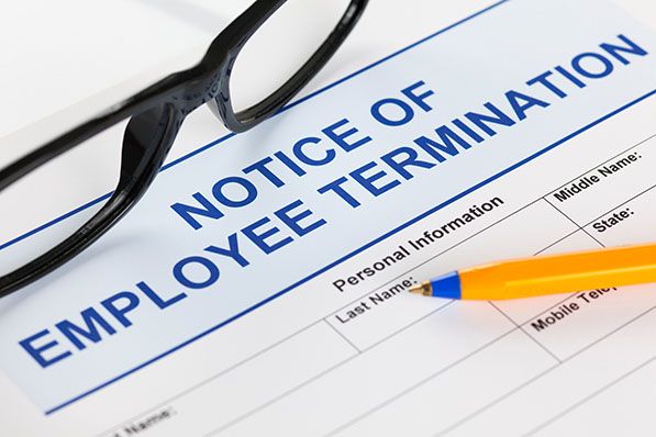 Notice of Employee Termination form with a pen and glasses.