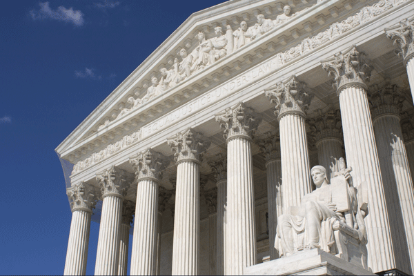 White columns and sculptures on the facade of the U.S. Supreme Court building.