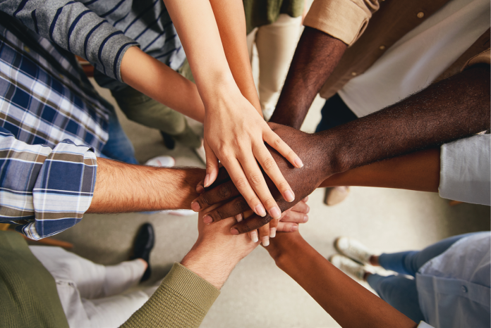 An overhead view of a group stacking their hands together.