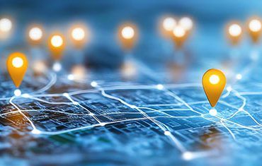 Glowing location pins and connecting lines spread across a blue digital map.