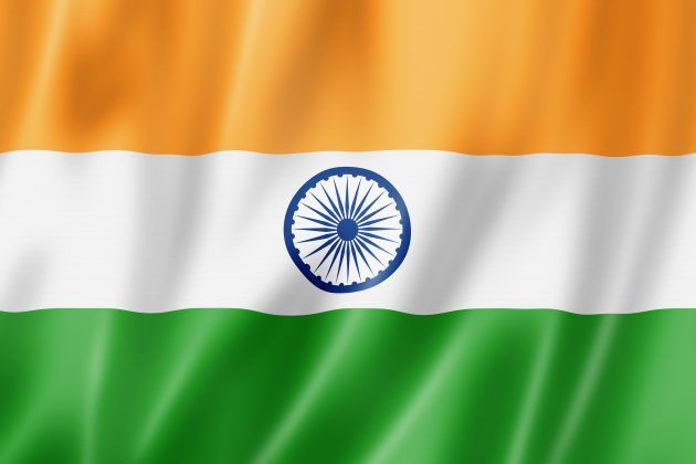 Indian flag with saffron, white and green stripes and a blue Ashoka Chakra on rippling fabric.