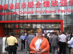 A woman poses in front of a crowded entrance labeled Welcome to Chinese Provinces Pavilion.