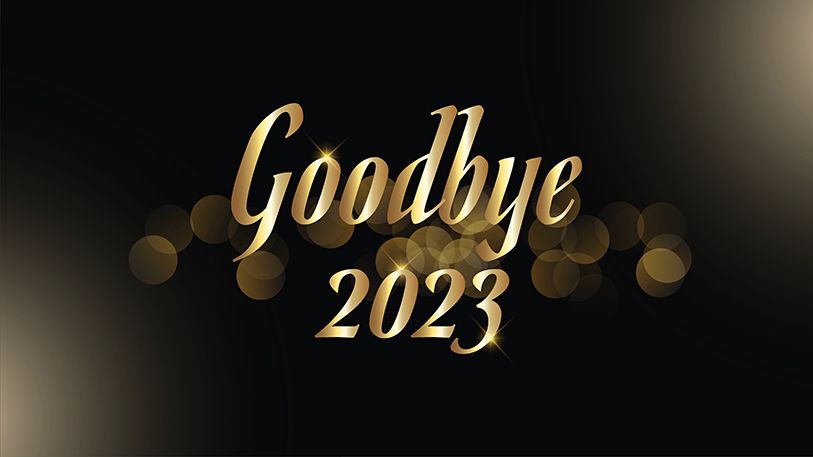 Gold script reads Goodbye 2023 against a black background with blurred lights.