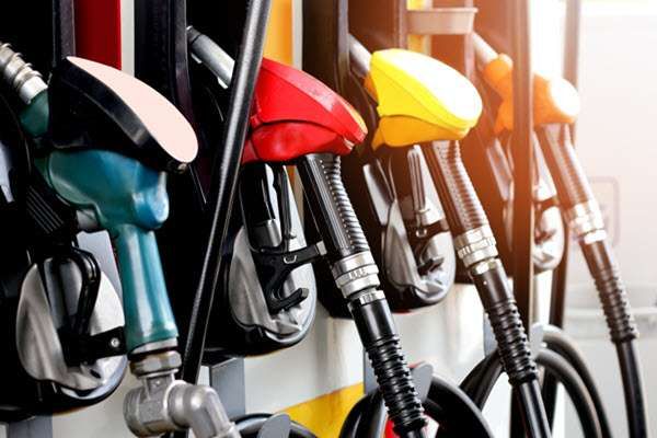 A row of fuel pump nozzles with green, black, red and yellow handles.