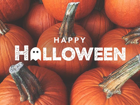 White HAPPY HALLOWEEN lettering over a close-up photograph of orange pumpkins.