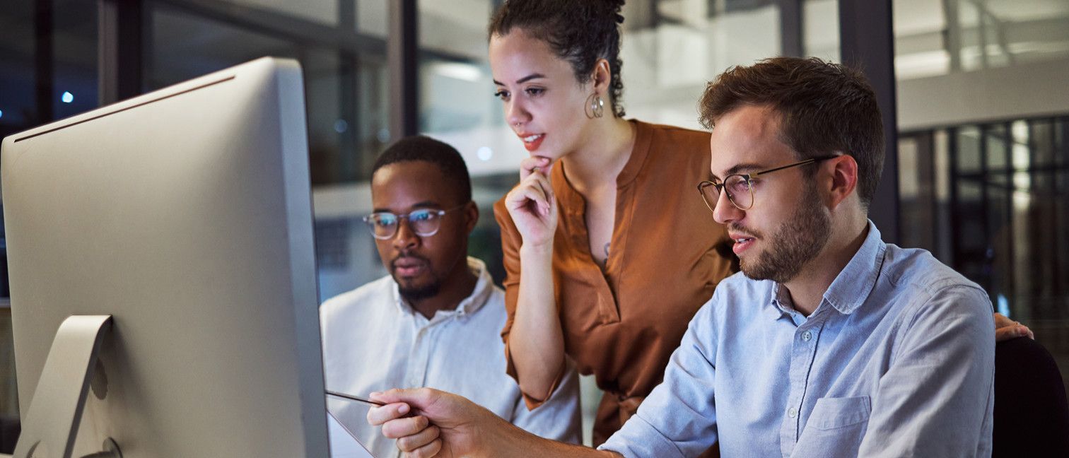 Three people looking at computer