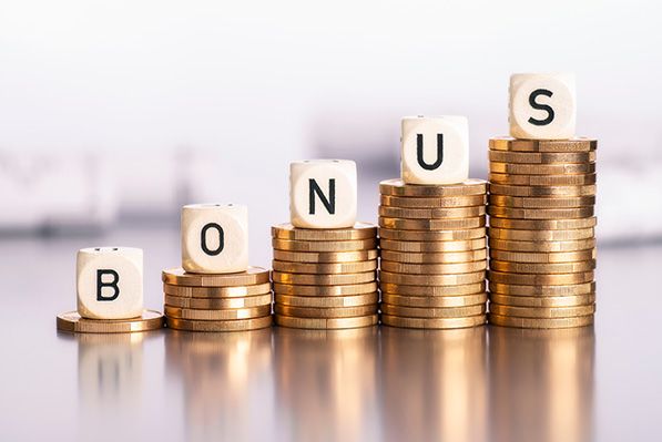 Wooden blocks spell BONUS on stacks of coins increasing in height.