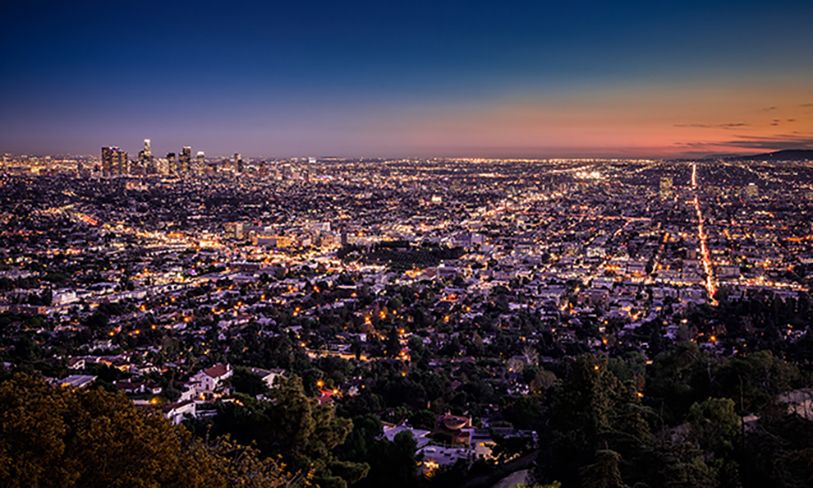 Wide view of Los Angeles lights stretching toward the horizon at dusk.