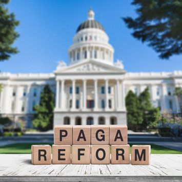 Wooden blocks spell PAGA REFORM in front of the California State Capitol.