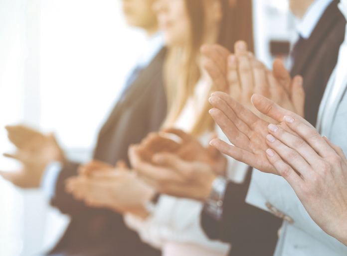 Close-up of people in business clothing applauding.