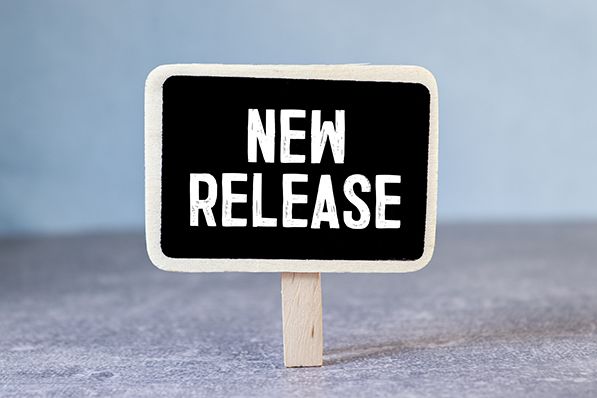 A small black sign on a wooden stick reads NEW RELEASE.