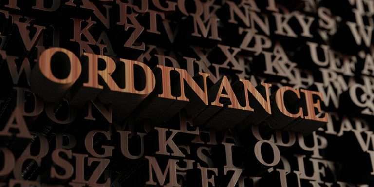 The word ORDINANCE stands out among a jumble of dark three-dimensional letters.