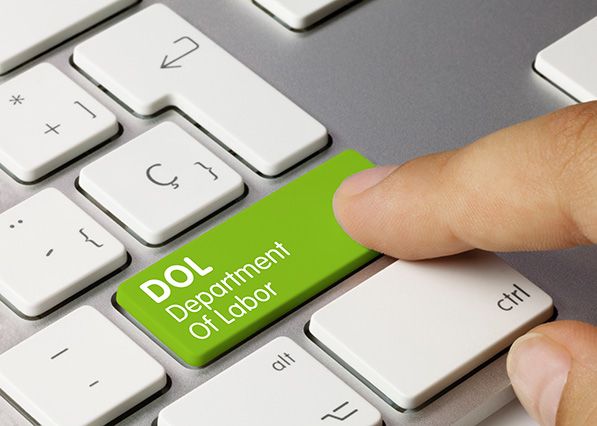 A finger presses a green keyboard key labeled DOL Department Of Labor.