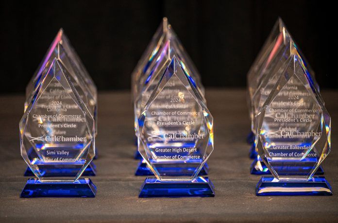Three pointed glass CalChamber President’s Circle awards on blue bases.