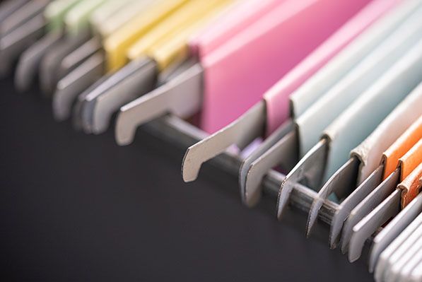 Close-up of colorful hanging file folders with blank gray tabs.