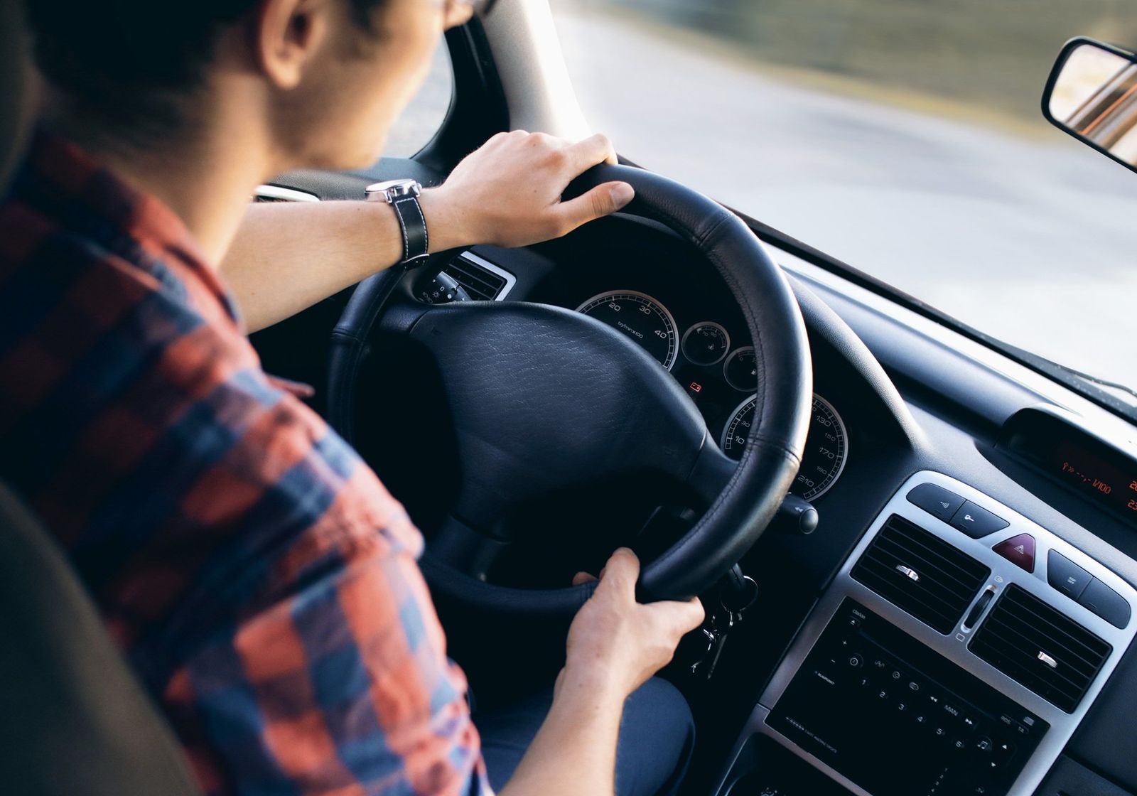 A driver's hands resting on a steering wheel
