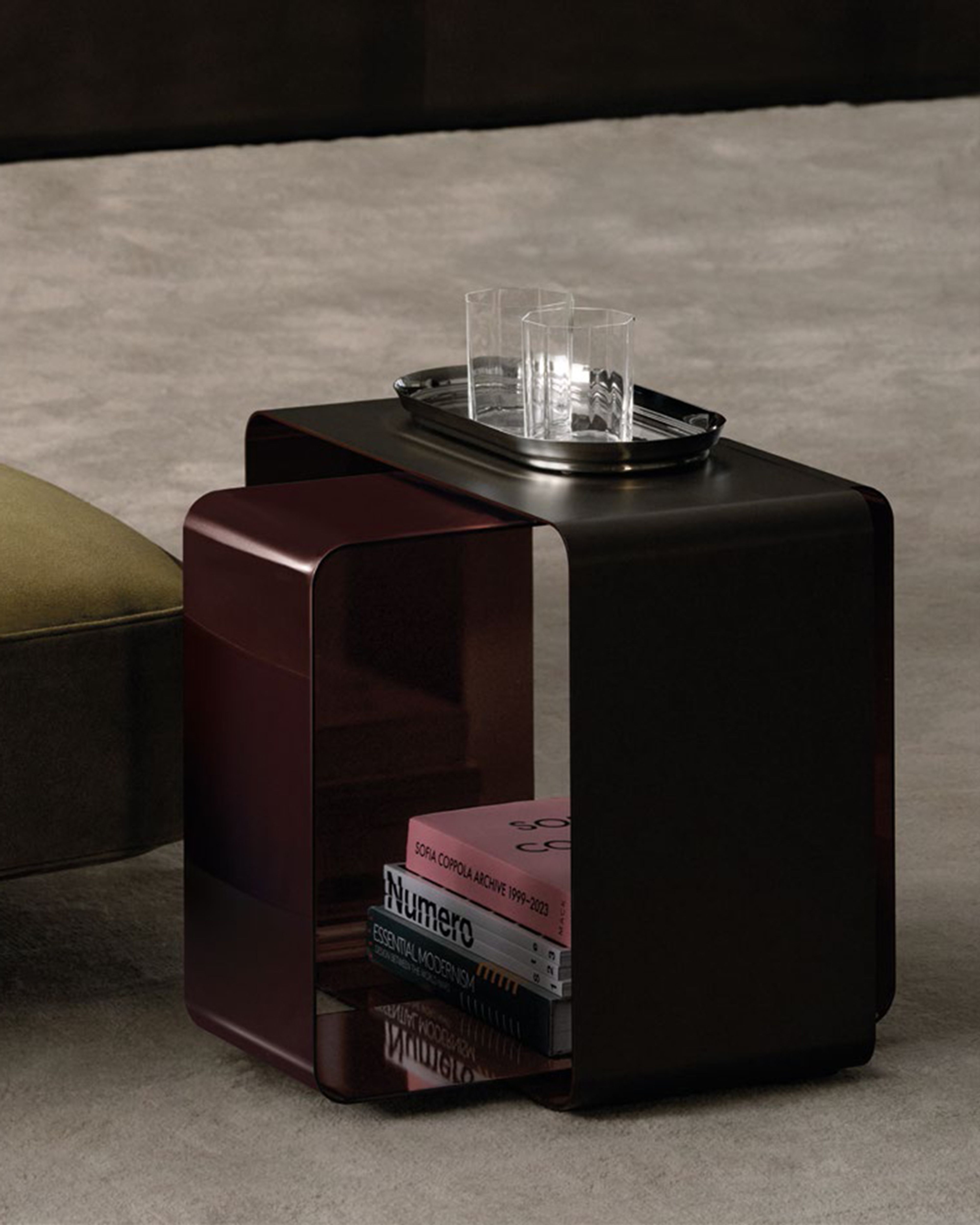 Coffee table defined by a fully metal construction based on the intersection of two curved rectangular bands.