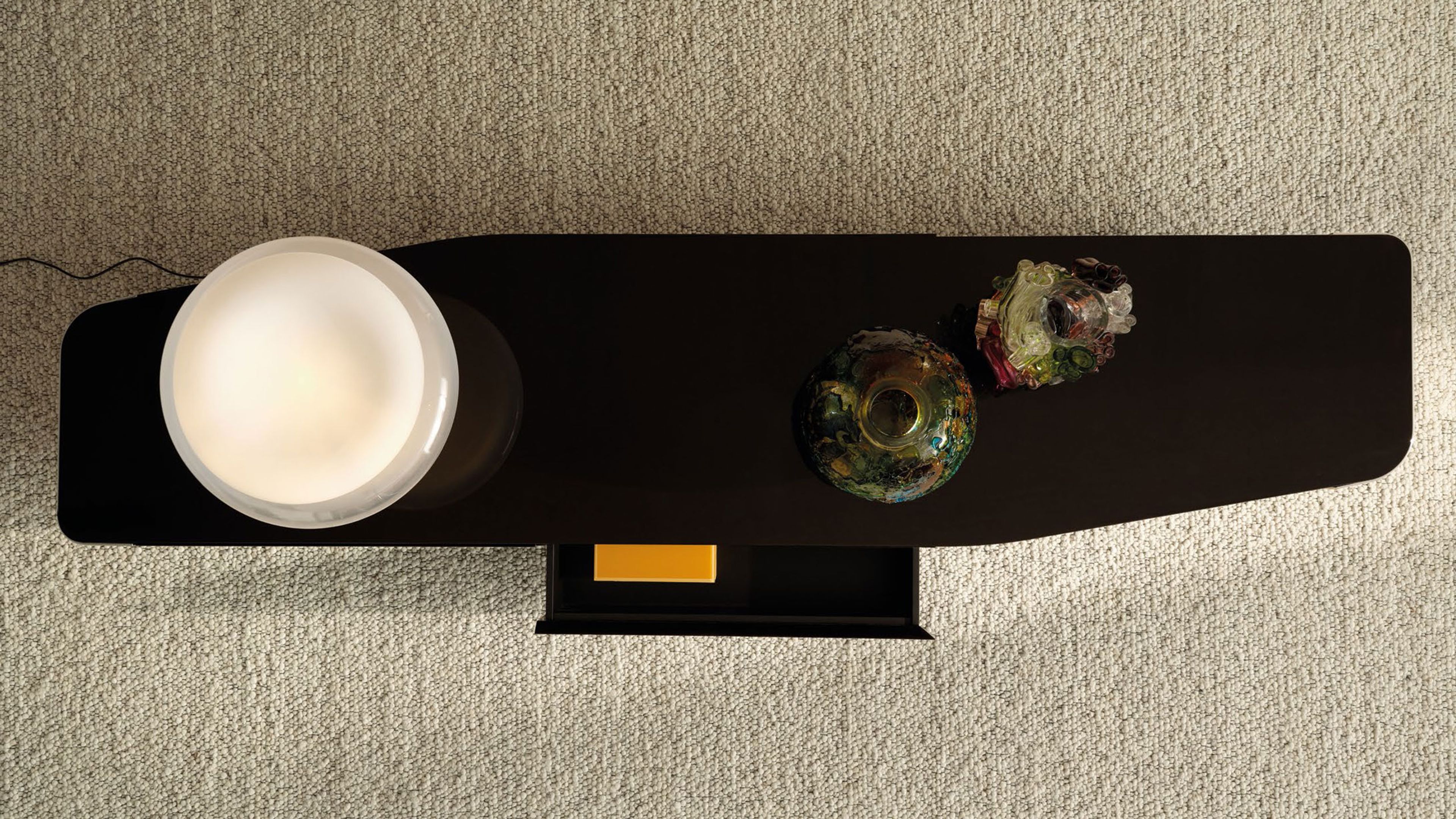 The glossy lacquered Minotti sideboard with metal details.